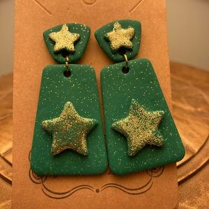 Green dangle earrings with gold glitter and star design.